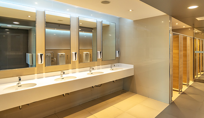 Clean restroom with mirrors, sinks, and stall doors