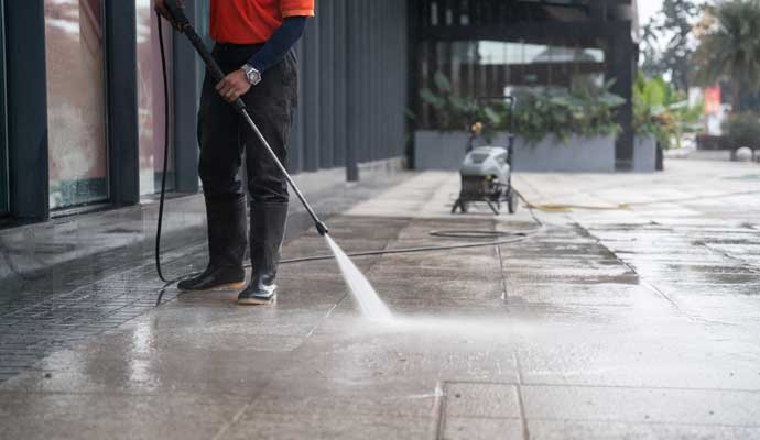 Person pressure washing a commercial space