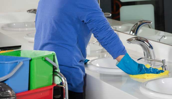 Person is cleaning a restroom with equipments