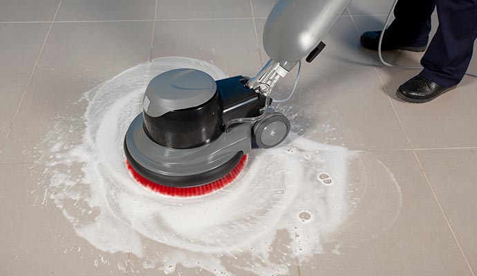 Professional cleaning a floor using equipment