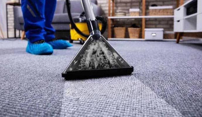 Professional cleaning a carpet using equipment