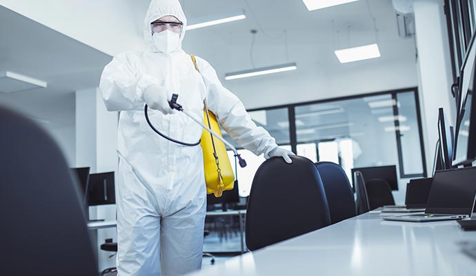 Professional worker disinfecting a room