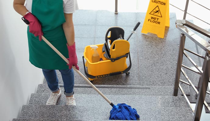 Professional cleaner mopping stairs