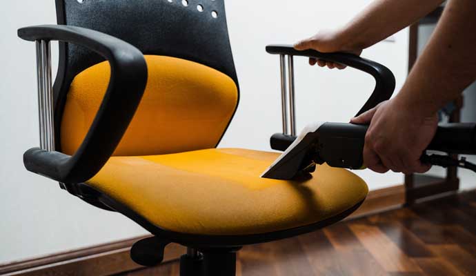 Expert cleaning a chair in an office
