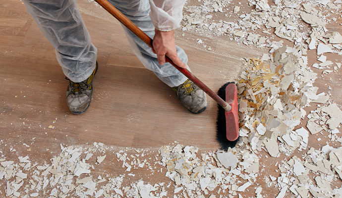 Expert sweeping construction debris from floor