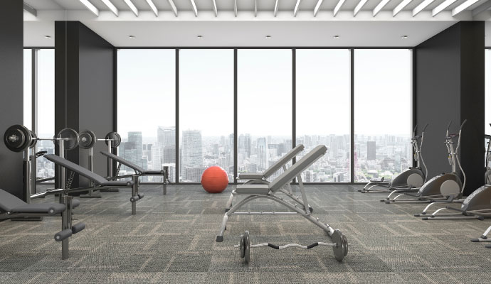 A wide clean carpeted interior view of a modern gym