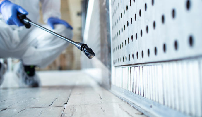 Professional spraying disinfectant tiled floor.