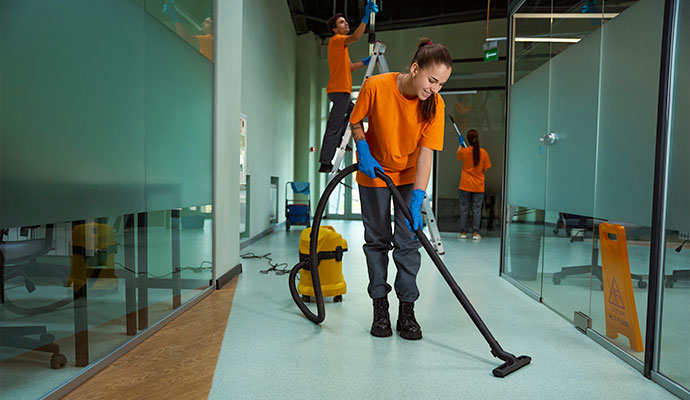 Day porters cleaning office space with equipment