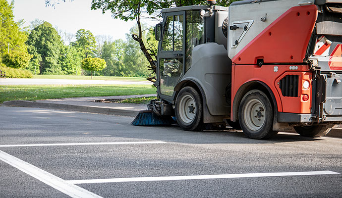 Sweeper truck cleaning a parking lot curb