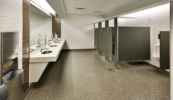 Large commercial restroom interior with sinks, stalls, and urinals