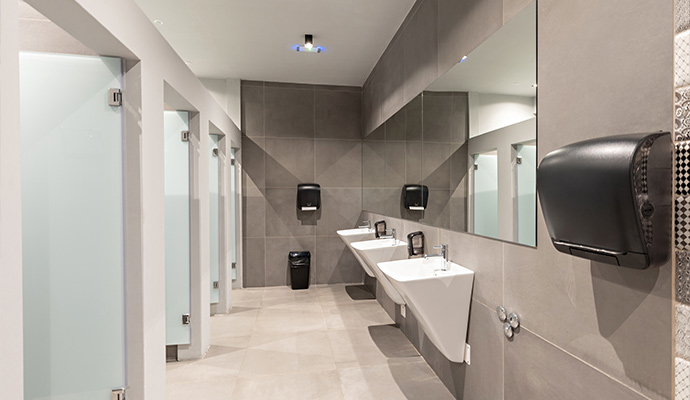 Modern commercial restroom with sinks, mirrors, and stalls