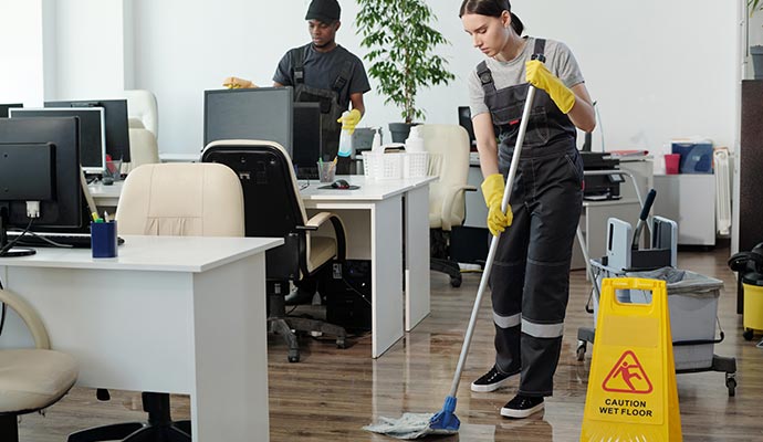 Professional cleaning team cleaning and mopping office floor