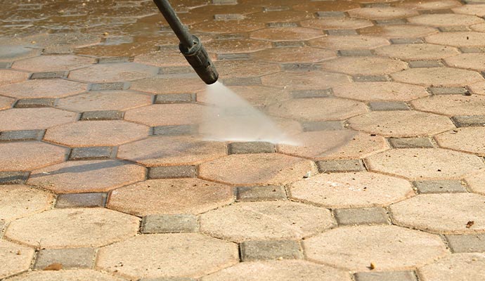 Professional worker cleaning floor with pressure washer