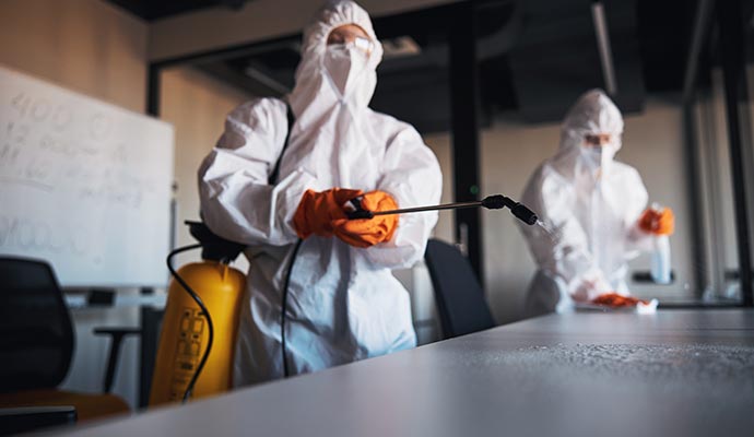 Professionals disinfecting office tables in a commercial workspace