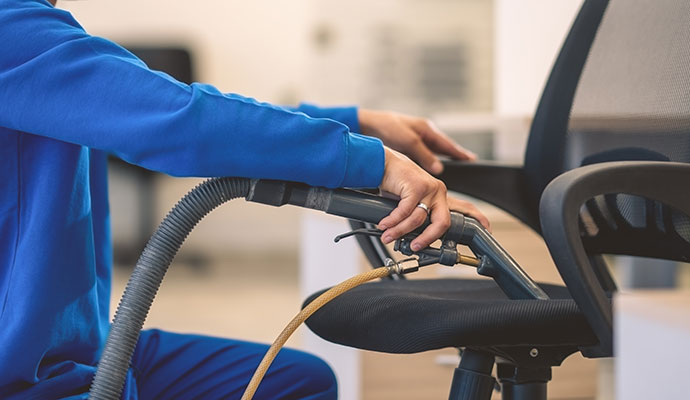 Technician cleaning office chair upholstery